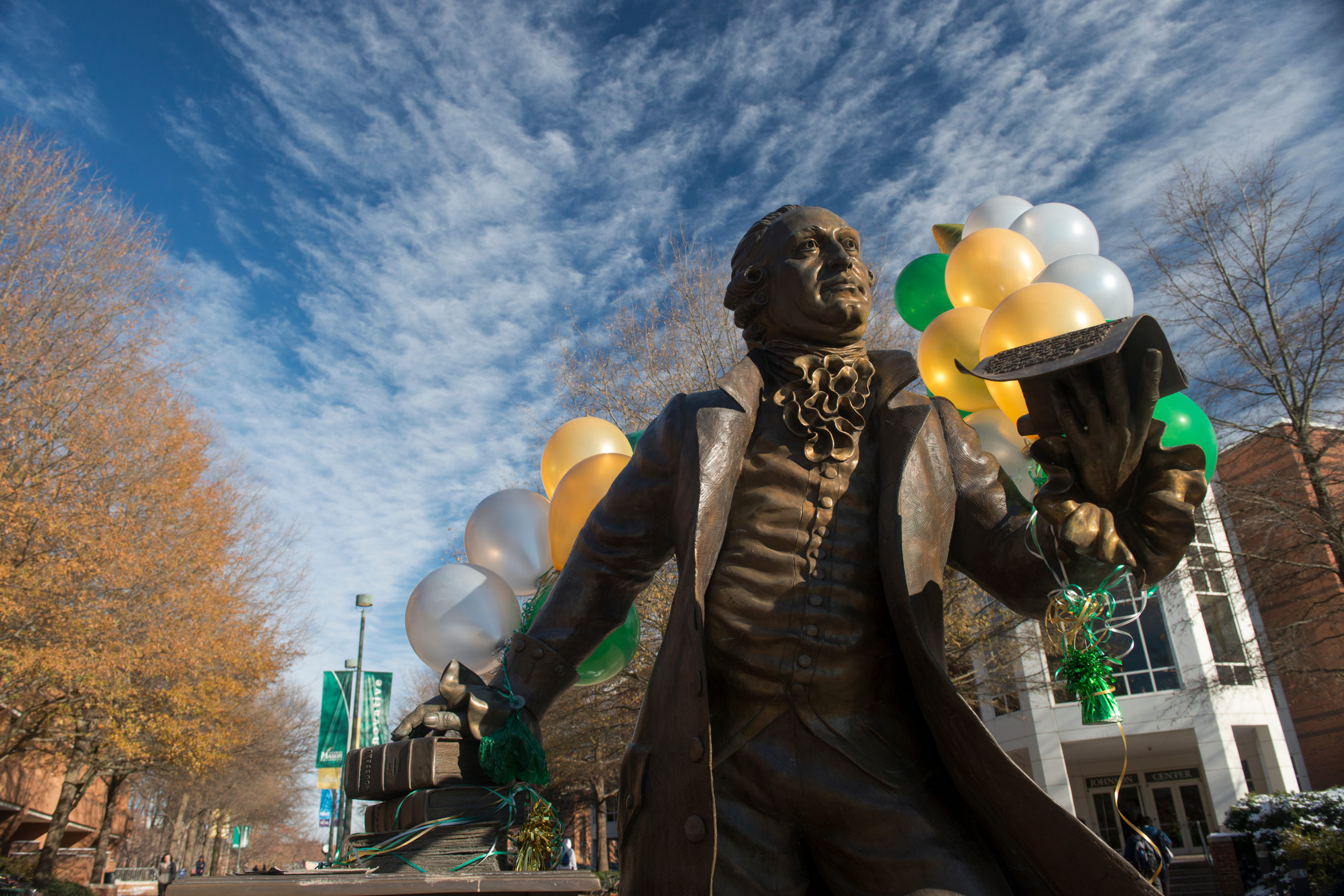 George Mason statue with green and gold balloons. Photo by Evan Cantwell/Creative Services/George Mason University