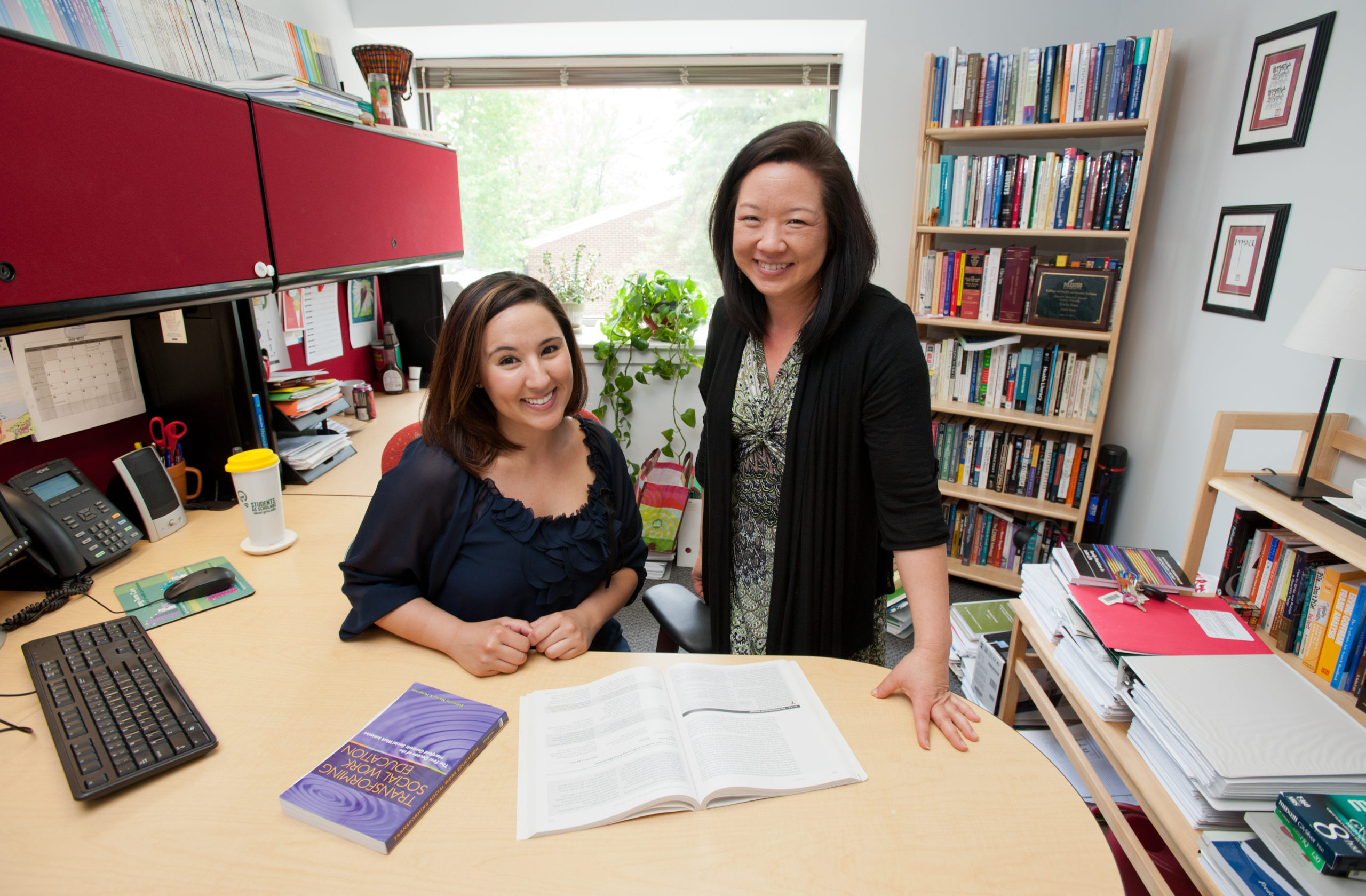 OSCAR/URSP portrait of student Kimberlee Velazquez (L) working on her research with Prof. Emily Ihara at the Social Work office. Photo by Alexis Glenn/Creative Services/George Mason University