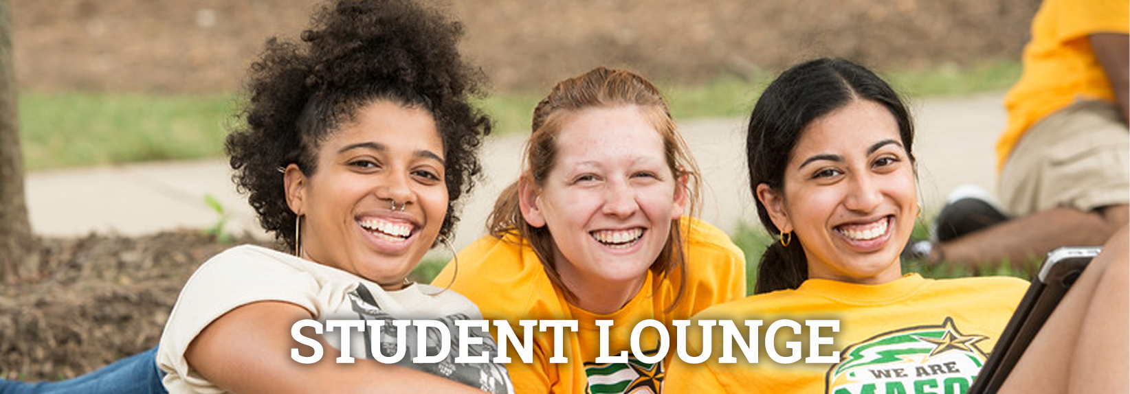Three students smiling on the lawn. Click image to access Student Lounge Zoom Room